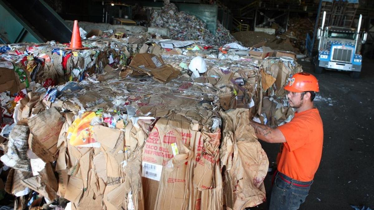 Samuel Juarez works on a bale of cardboard at Sunset Waste Systems in Fresno in 2013. What company should have the next recycling contract has become a political controversy at City Hall.