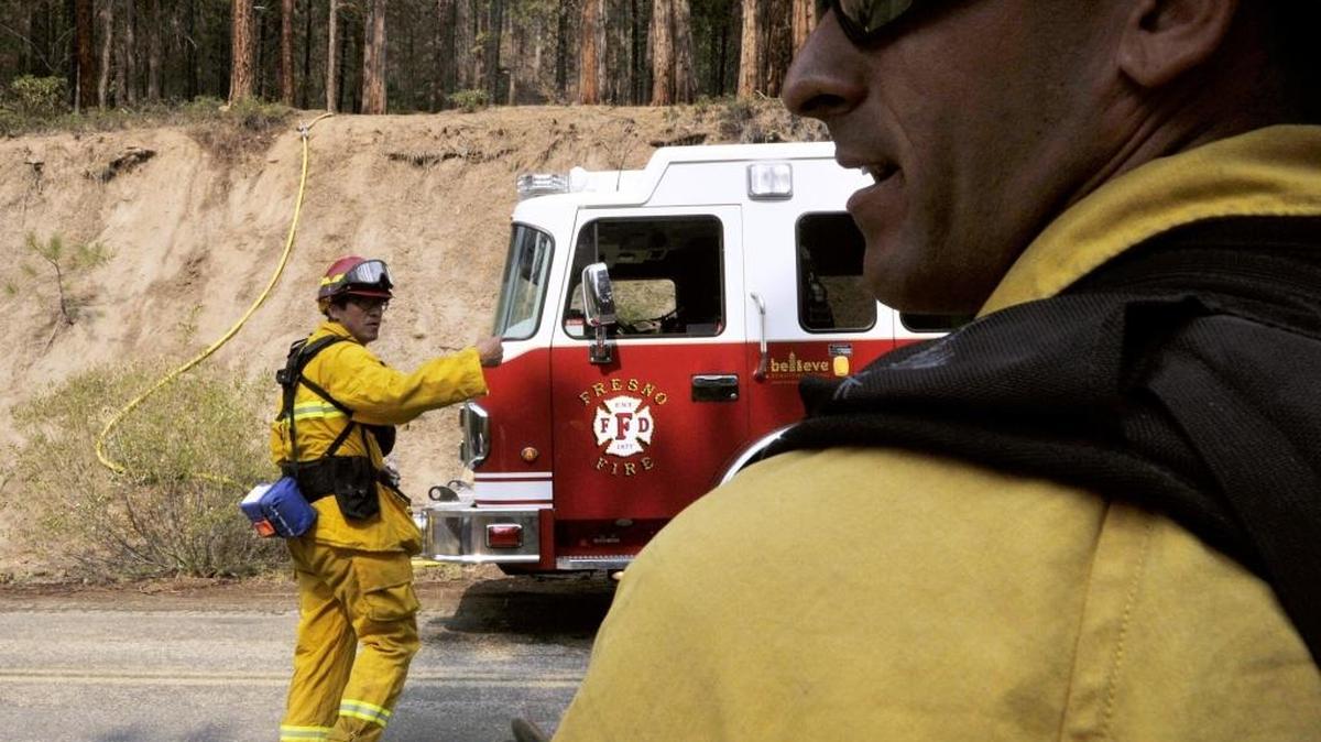 
Fresno Fire Capt. Bob Van Tassel, left, with other firefighters at a point along Ten Mile Creek Road, were keeping Hot Shots on the hill above them supplied with water as they fought the Rough fire along Ten Mile Creek Road on Aug. 22, 2015.
