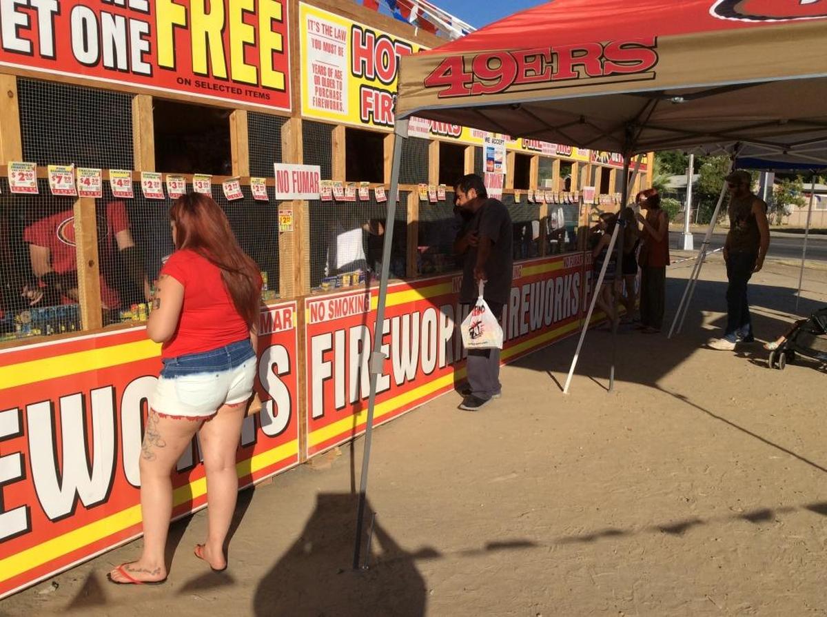 People stop by a TNT Fireworks stand in central Fresno in 2016.