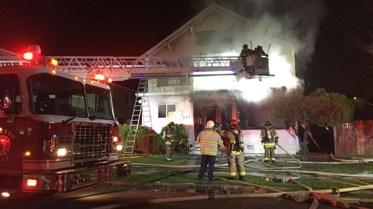 Fresno firefighters battle a two-alarm fire Wednesday evening at a turn-of-the-century house converted into six apartments in central Fresno.