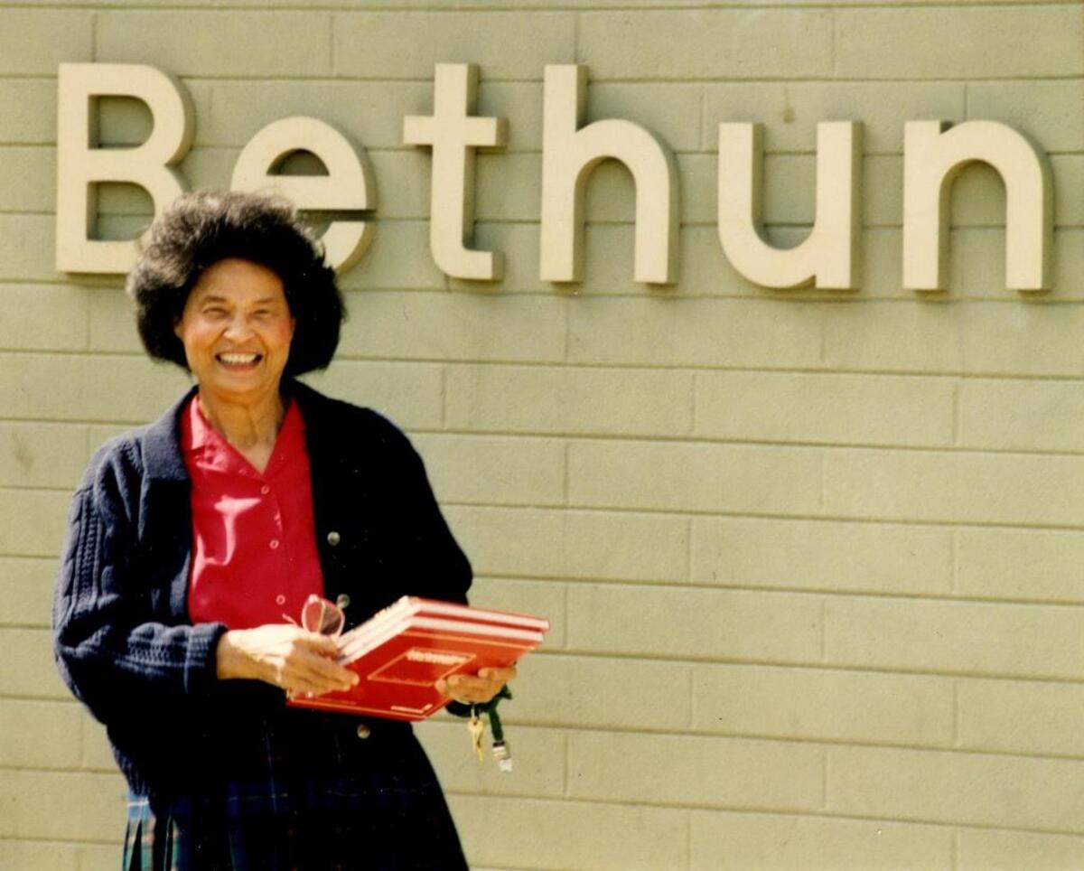 Mattie Meyers beside a sign for Bethune Elementary School in Fresno, where she worked as a teacher for many years.
