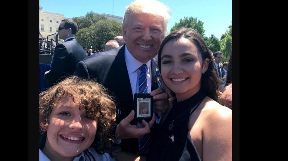 President Trump holds Fresno County Sheriff’s Sgt. Rod Lucas’ sheriff’s identification card as he poses with Lucas’ children, Elijah and Gianna Lucas, at the Capitol in Washington, D.C., on Monday, May 15, 2017.