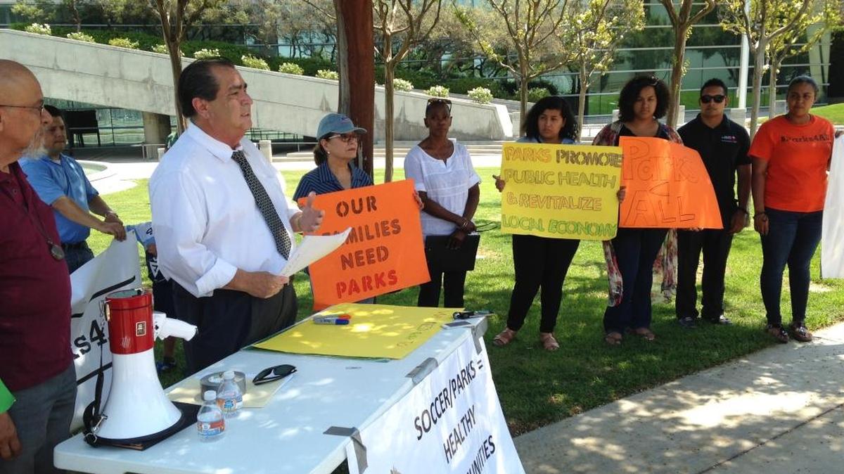 Pastor Juan Saavedra (far left) and other southeast Fresno residents look on as Jose Leon-Barraza (third from left) speaks to reporters Thursday in front of Fresno City Hall. Leon-Barraza is the CEO of the Southeast Fresno Regional Park and Soccer Complex Authority, which wants the city of Fresno to join its effort to build a park and soccer fields at a former U.S. Department of Agriculture research center on Peach Avenue south of Butler Avenue.