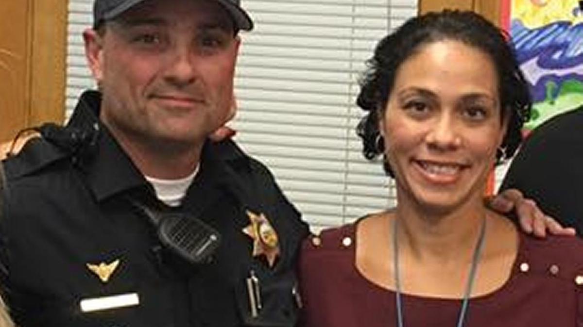 Clovis Police Cpl. Rich Ashcraft stands with Scandinavian Middle School vice principal Summer Gaston-Gehris after giving her an envelope containing $300 collected at the police department for the family of a student who died tragically.
