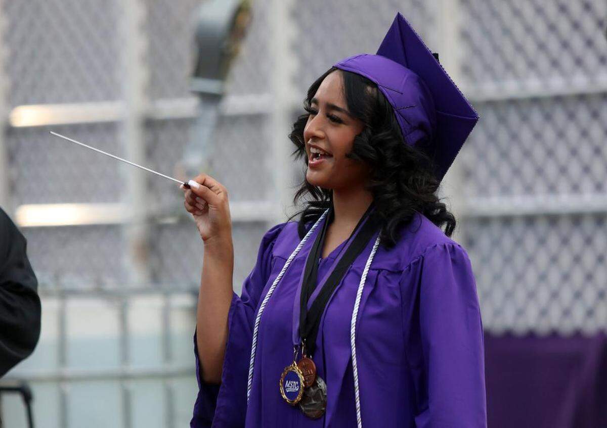 Madera South High graduate Leslie Rey Ramírez directs the band during the graduation ceremony at Madera Memorial Stadium on June 7, 2023.