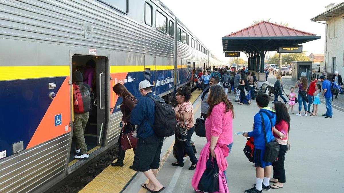 Travelers begin boarding an Amtrak train in Fresno on a busier-than-normal Sunday afternoon, as holiday travel hits full stride.