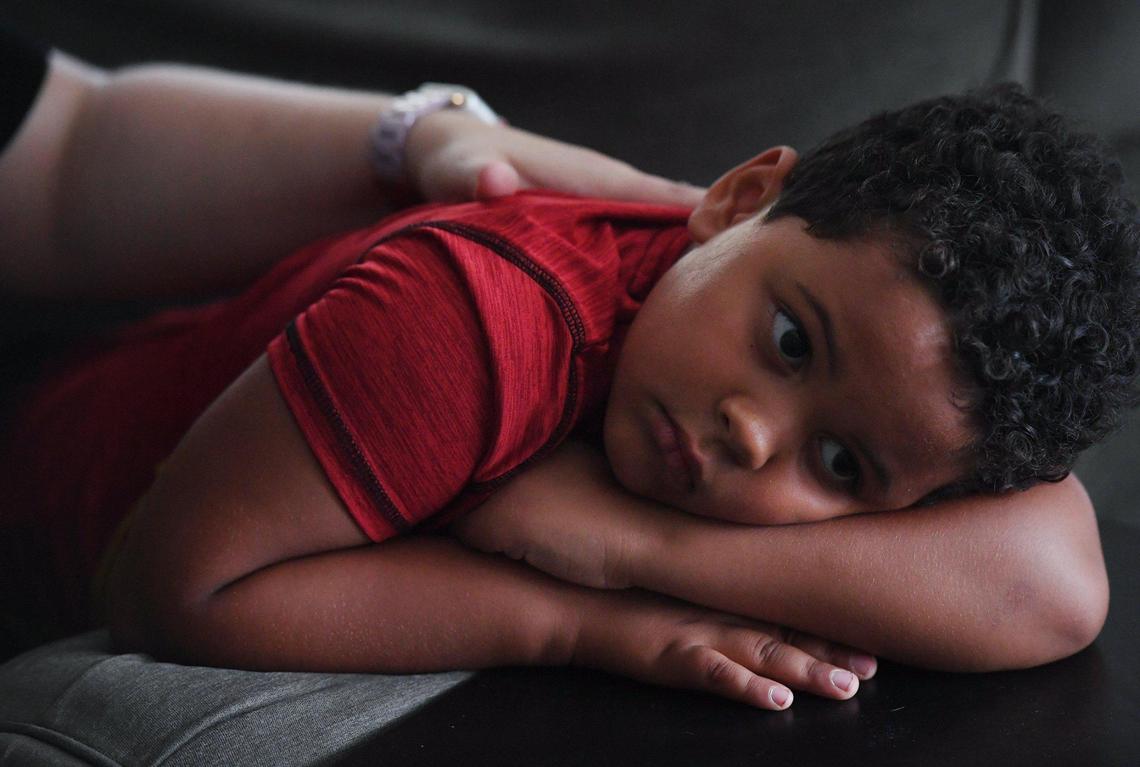 Jennifer Moore strokes her son’s back as she describes how her son Bryce Moore contracted COVID-19 at age 5. He later developed MIS-C. With the rise in COVID and kids returning back to school, she wants to warn others of the risk for kids. Photographed Thursday, Sept. 9, 2021 in Fresno.