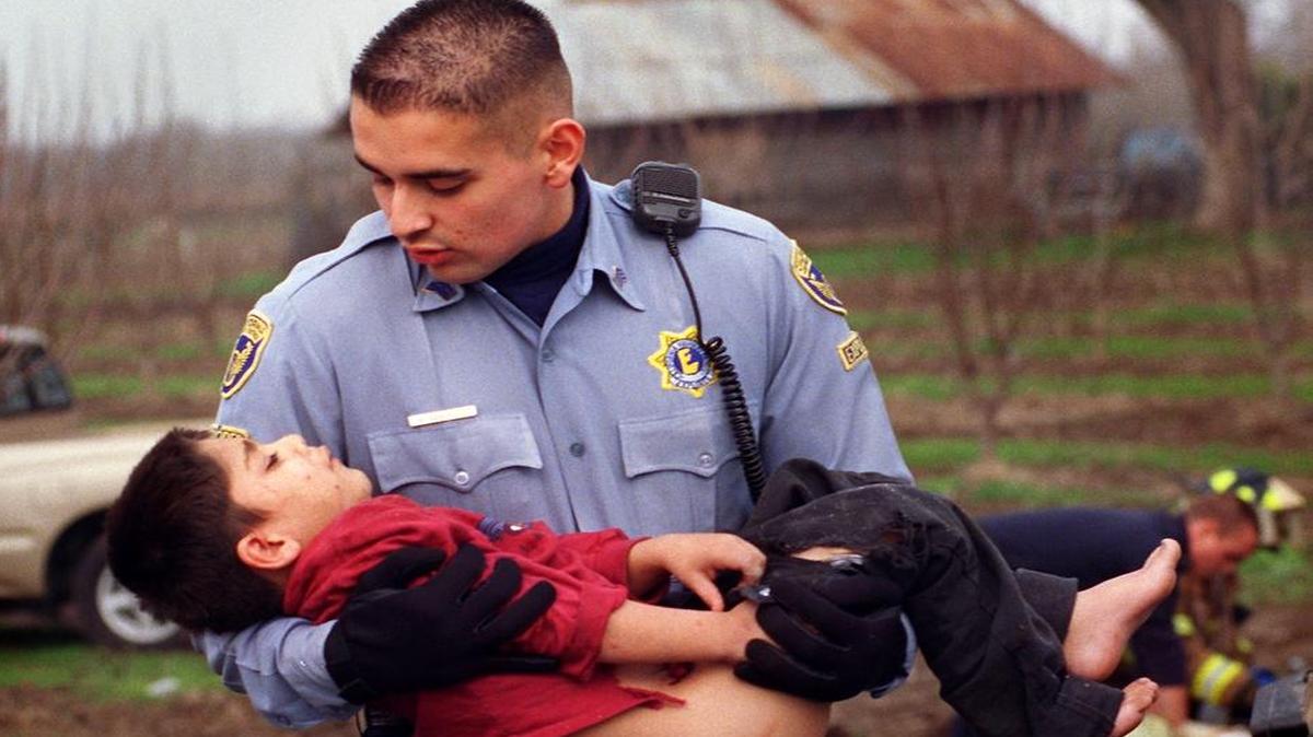 
California Highway Explorer Mayolo Banuelos carries an injured child to a waiting ambulance at the scene of a 1999 accident west of Modesto. Banuelos went on to a career as a CHP officer.
