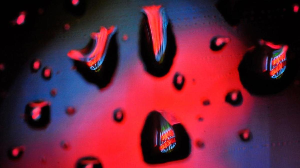 Iconic neon of Tokyo Gardens restaurant on Fulton Street are seen through raindrops on a car window during the Tuesday night’s storm.