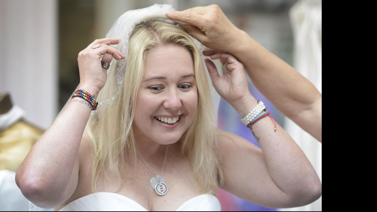 
Robin McGehee tries on a veil while doing her dress fitting at Elegant Bride in Fresno. 

