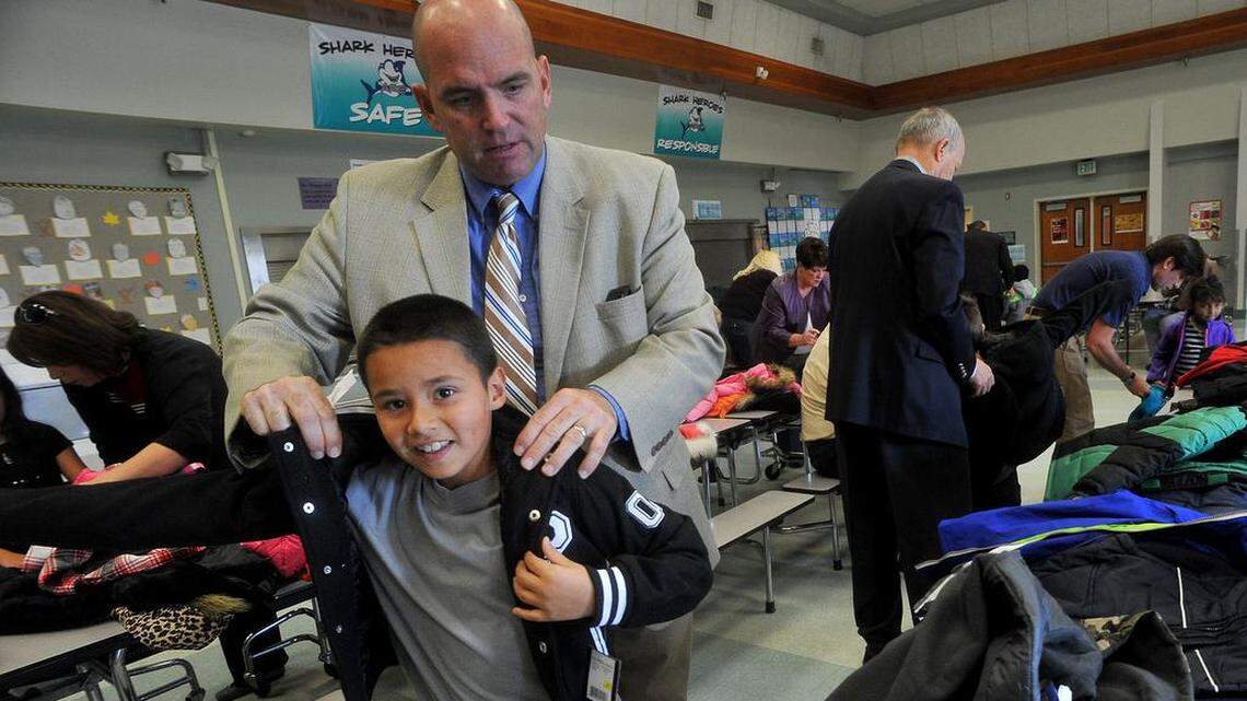 Steinbeck Elementary third grader Giania Travis happily picks out a coat with help of Kelly Porterfield, Central Unified School District Chief Business Officer, during the annual Foundation of Central Schools Coats for Kids program, Wednesday morning, November 20. 2013.