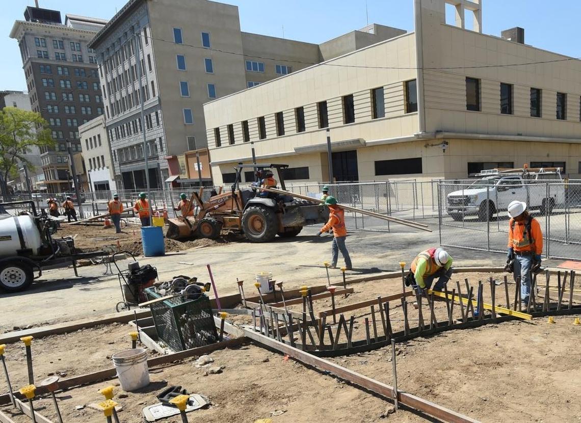 Construction workers set curbing forms at Merced and Fulton during Fulton Mall renovation Wednesday morning.