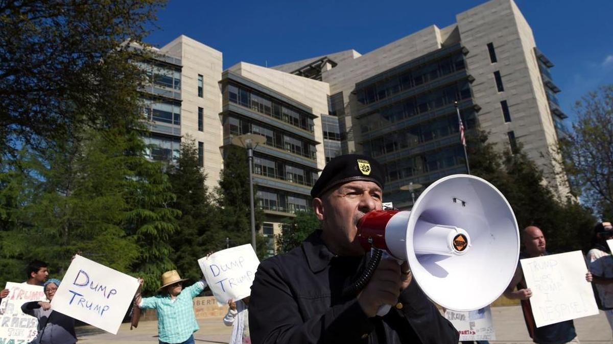 Juan Avitia, center, uses a bullhorn to address passing motorists as about 50 people gather outside Robert E. Coyle Federal Building in downtown Fresno on March 31, 2016, calling for voters to vote for someone other than Donald Trump. Latino voter registrations have surged in California, driven at least in part by Trump’s statements about Latinos.
