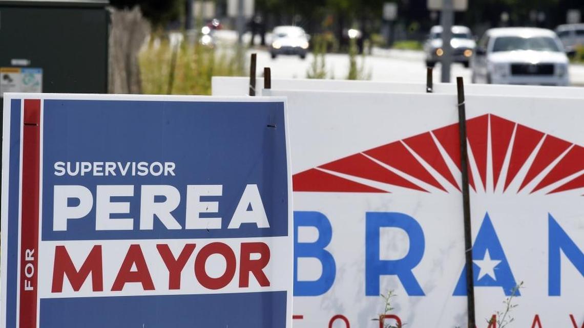 Election signs for the Fresno mayoral races of Henry R. Perea and Lee Brand are seen near Nees and Palm Avenues on Wednesday morning.