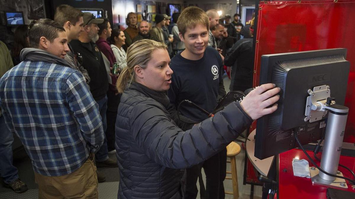 Tour manager Sarah Rowe shows the results of a virtual welding simulation to Dakota Arguello during the Welding Expo at American River College in Sacramento on Feb. 6, 2016. The welding industry is in need of workers, and ARC is trying to attract students to train them for those careers.