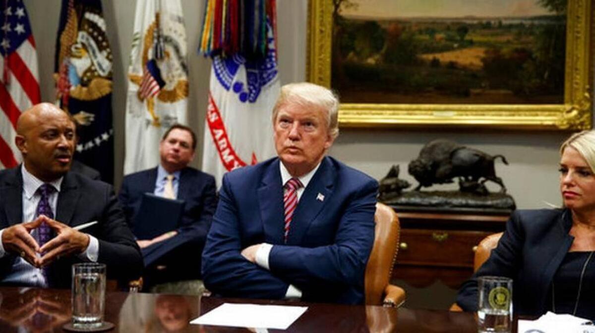 Florida Attorney General Pam Bondi, right, and President Donald Trump listen as Indiana Attorney General Curtis Hill speaks during a meeting with state and local officials to discuss school safety, in the Roosevelt Room of the White House, Thursday, Feb. 22, 2018, in Washington, D.C.