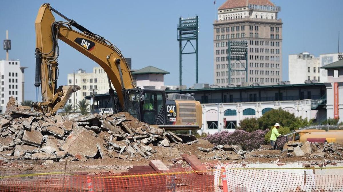 This Sept. 27, 2016, photo shows an excavator breaking up what is left of an old warehouse in the 700 block of G Street in downtown Fresno, part of a project to lay track for the bullet train in the San Joaquin Valley.
