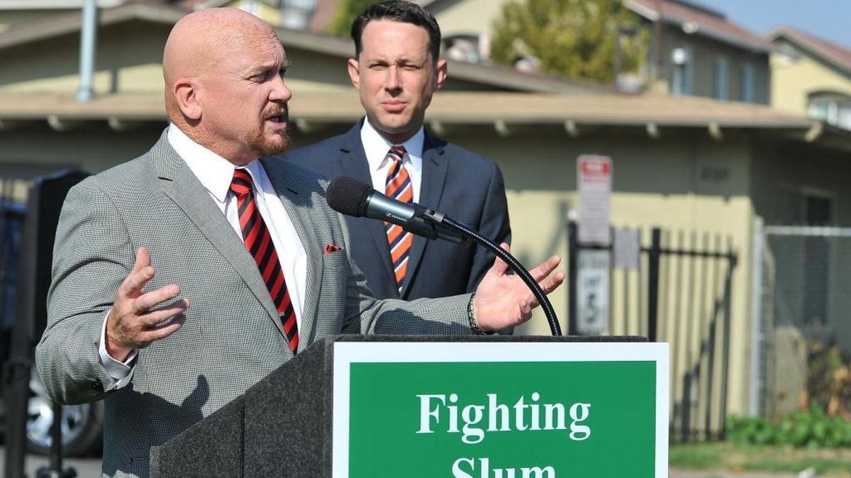 Council Members Steve Brandau, left, and Clint Olivier hold a press conference to announce their solution to address slum housing in Fresno with the creation of ASET, the Anti-Slumlord Enforcement Team, in front of the Summerset Village Apartments on Monday morning, Nov. 14, 2016.