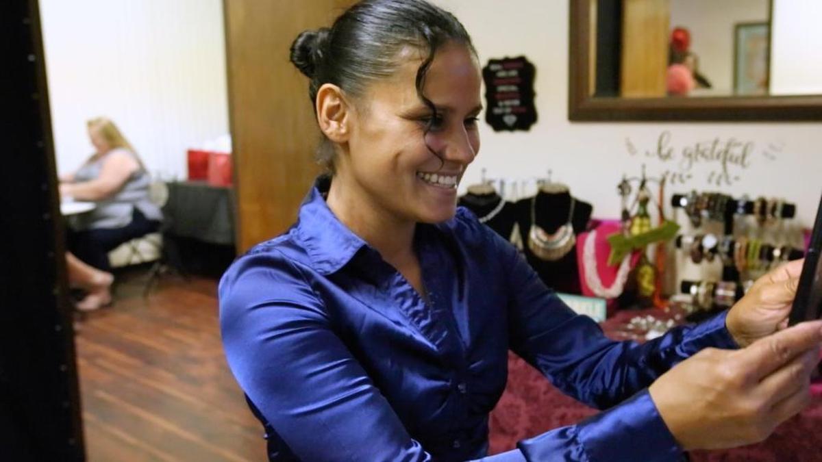 Rebecca Rodriguez-Brown smiles at her reflection after a makeover from Beauty for Ashes, a nonprofit organization that hosts Glam and Sparkle events for victims of domestic violence and human trafficking.