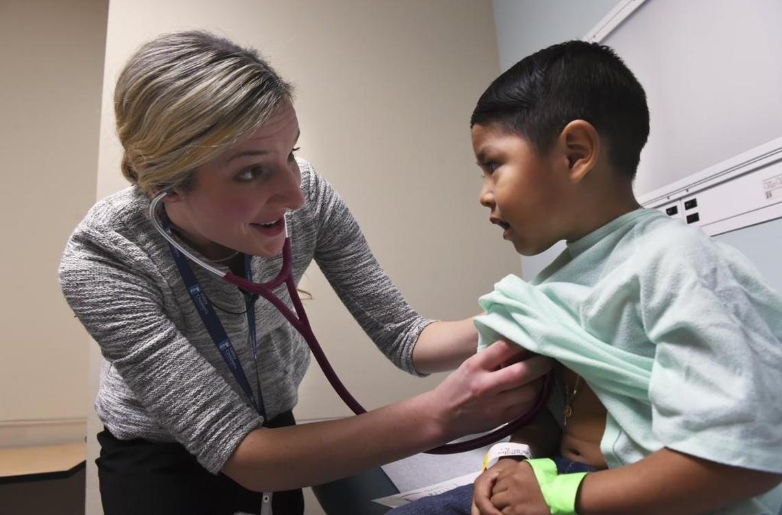 First-year pediatric resident Devon Goossen, left, checks on a young patient at Valley Children’s Hospital.