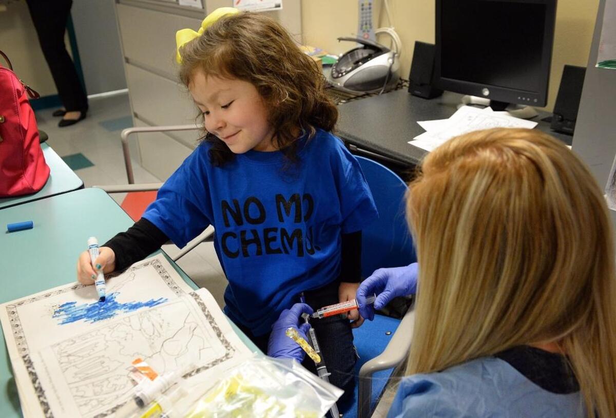 Samantha “Sammy” Leal, 4, colors while receiving the last of her chemotherapy treatments for a tumor from nurse Jennifer Bustillos at Valley Children’s Hospital on Monday, Jan. 30, 2018.