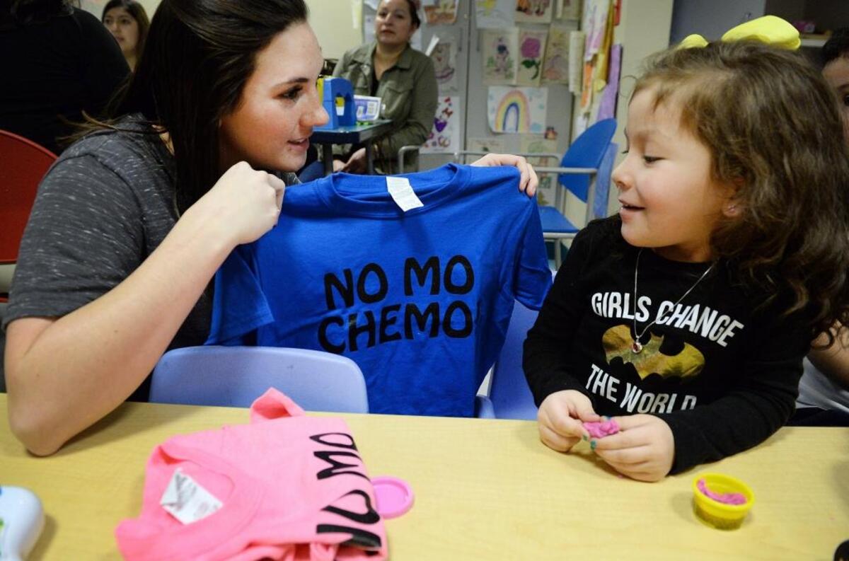 Samantha “Sammy” Leal, 4, is presented with a “No Mo Chemo” T-shirt by child life specialist Joy Johnson on the last day of her chemotherapy treatments for a tumor at Valley Children’s Hospital on Monday, Jan. 30, 2018.
