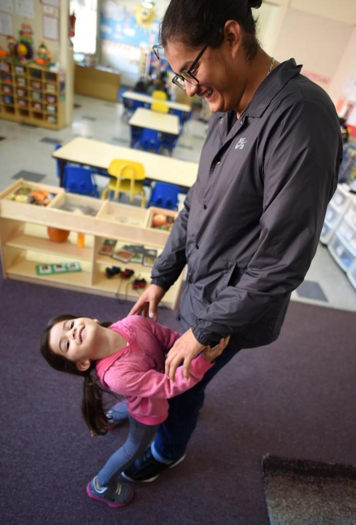 Three-year-old Emma plays with her father, 18-year-old Kevin Aguilar, at Sequoia Head Start before he heads to class at the School of Unlimited Learning.