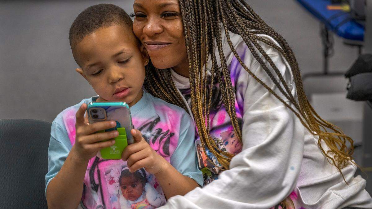 Marquisha Brown, de 29 años, habitante del condado de Yolo, abraza a su hijo Elijah durante una visita al centro de recursos familiares de la Alianza Infantil del Condado de Yolo, en West Sacramento, en marzo. Marquisha atribuye al programa de ingreso básico de Yolo darle tiempo para ayudar a su hijo a superar su trauma. El Condado de Fresno pondrá en marcha su propio programa de ingreso básico en el verano de 2024.