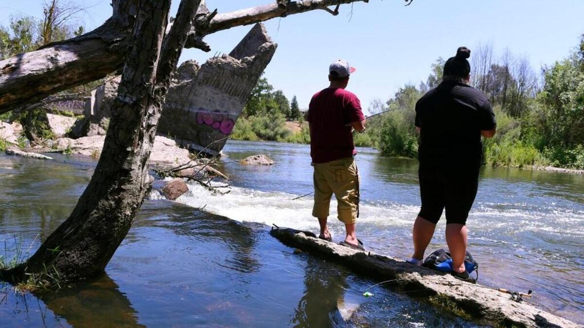 Cheng Her, left, and his wife Linda Moua, right, fish the San Joaquin River at Friant's Broken Bridges Tuesday afternoon, May 15, 2018.