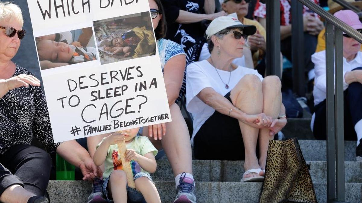 Christopher Baker, 3, holds a sign that reads “Which baby deserves to sleep in a cage?” as he attends a Poor People’s Campaign rally with his mother, Katie Baker, behind sign, Monday, June 18, 2018, at the Capitol in Olympia, Wash. U.S. President Donald Trump defended his administration’s border-protection policies Monday in the face of rising national outrage over the forced separation of migrant children from their parents.