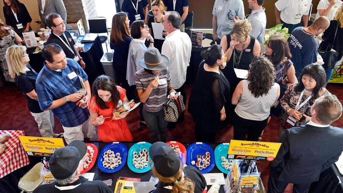 People make their way through the aisles of vendors at the Fresno Food Expo new product awards preview night at the Saroyan Theater in Fresno on July 8, 2015.