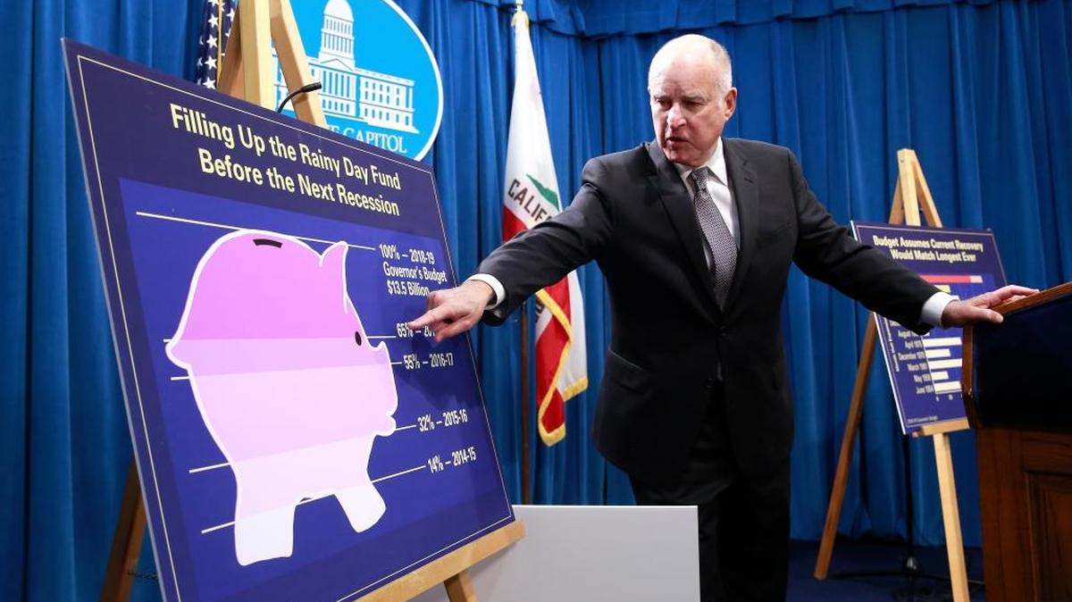 Gov. Jerry Brown points to a chart showing the growth of the state’s rainy day fund.