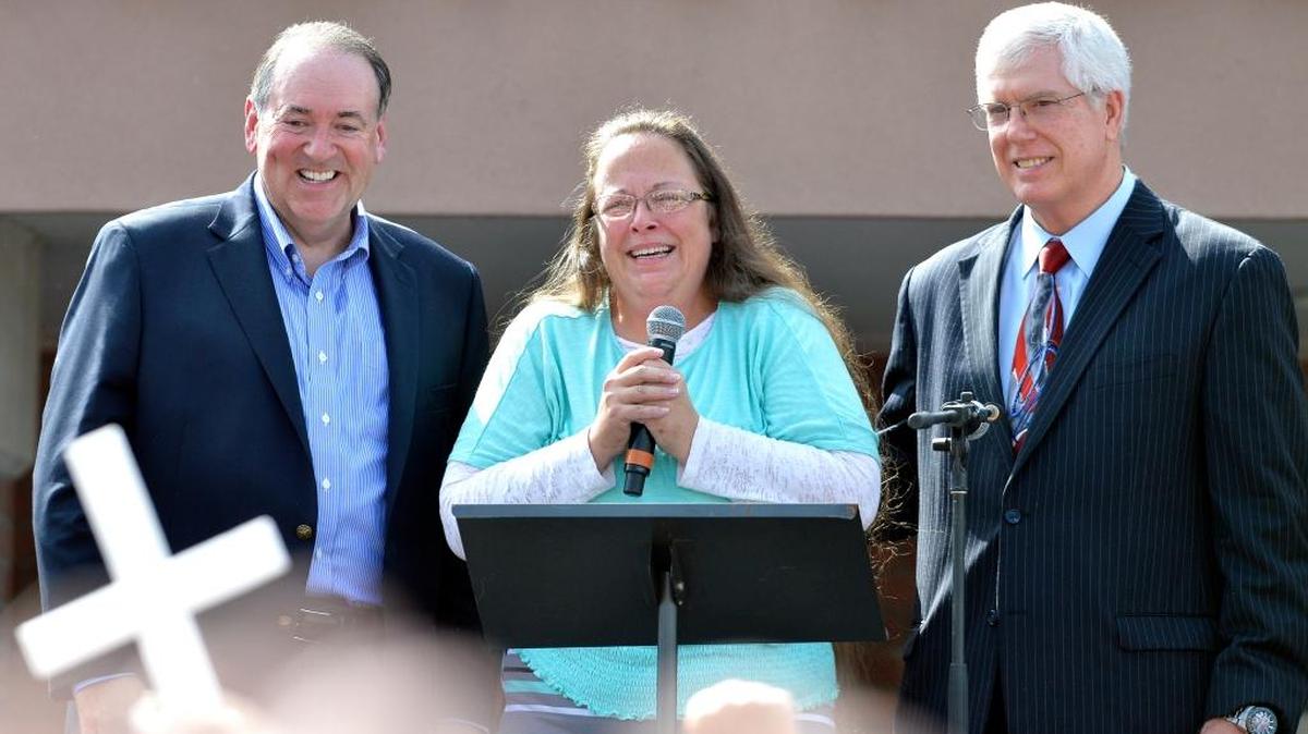 
Rowan County Clerk Kim Davis, center with Republican presidential candidate Mike Huckabee, left, and attorney Mat Staver, right, founder of the Liberty Counsel, the Christian law firm representing Davis, at her side, greets the crowd after being released from the Carter County Detention Center, Tuesday, Sept. 8, 2015, in Grayson, Ky. 
