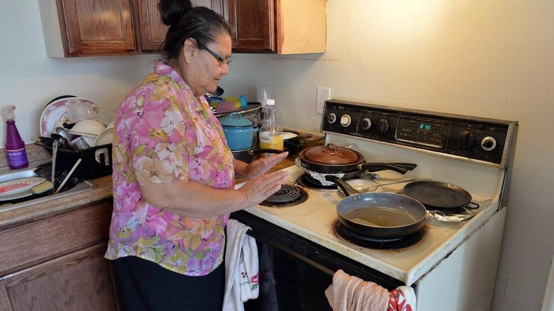 In this file photo, Consuelo Yanez, 58, holds her hand over a burner to see if it will turn on while cooking lunch at her apartment at 276 N. Diamond St. on March 7 in central Fresno. Yanez, who lives there with her husband and daughter, says that only one burner works on the stove.