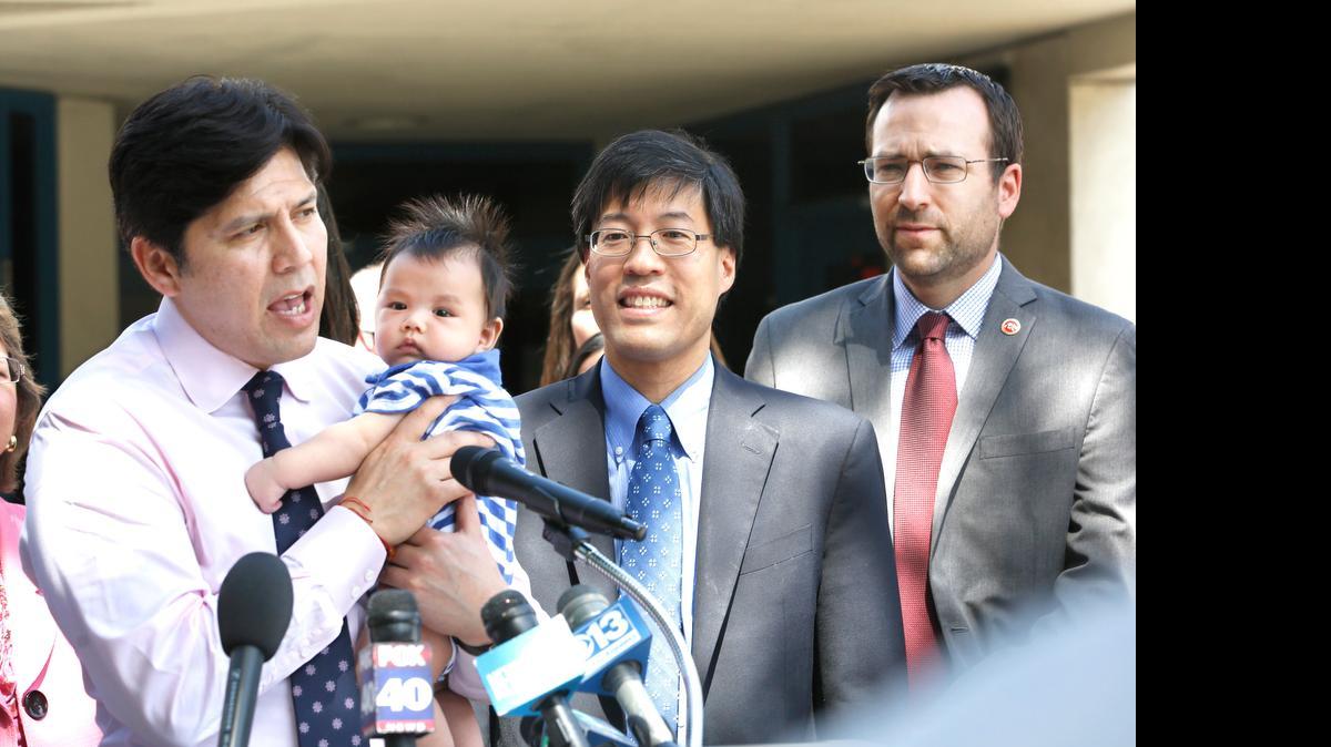 
Senate President pro Tempore Kevin de León, D-Los Angeles, holds Joshua Fulmer as he congratulates Sens. Richard Pan, D-Sacramento, center, and Ben Allen, D-Santa Monica, after their vaccination bill was signed by Gov. Jerry Brown on June 30. 
