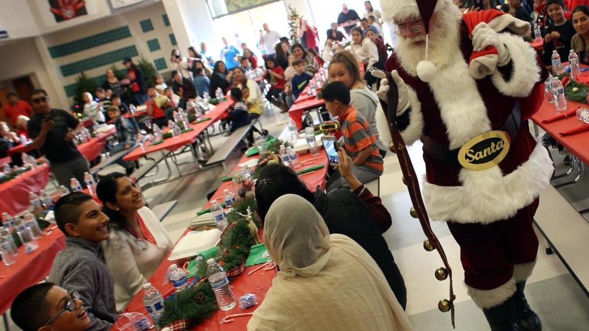 Santa Claus enters the cafeteria for the 24th annual Making Spirits Bright luncheon and Christmas giveaway at John Wash Elementary School in Fresno on Dec. 9.