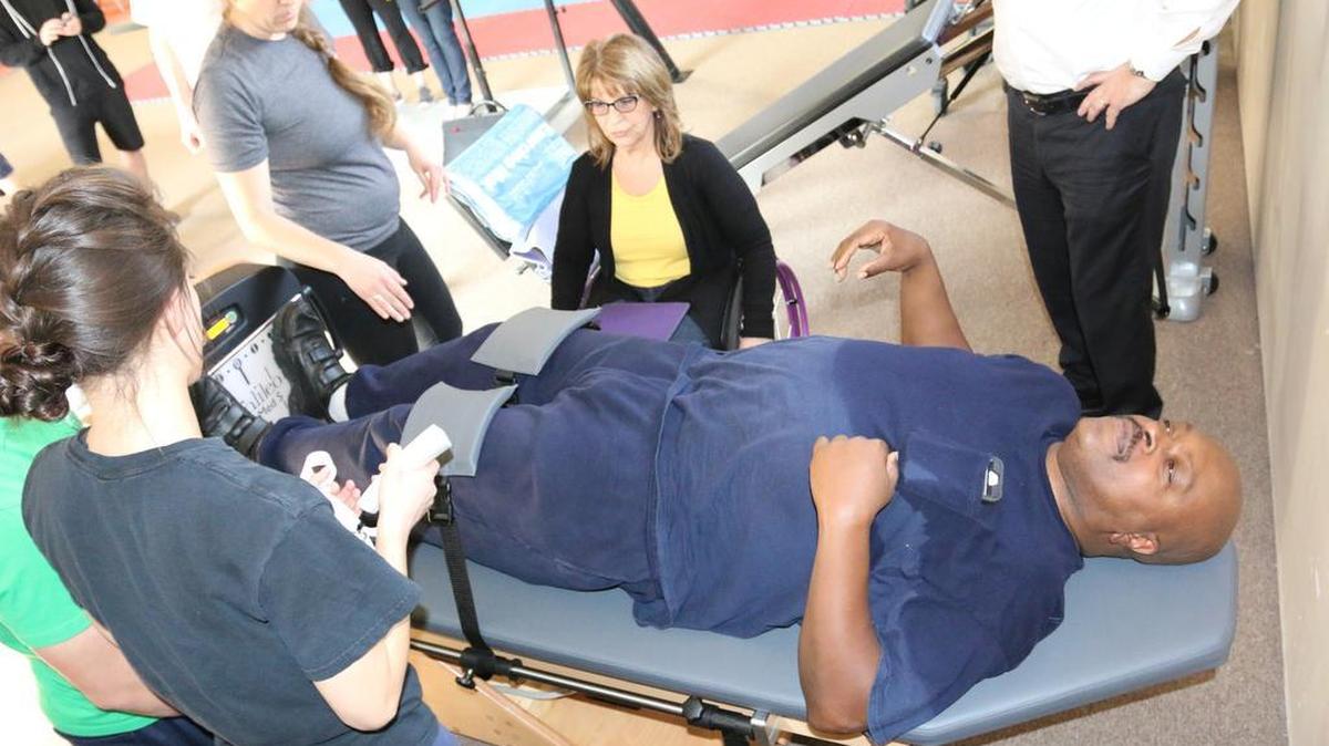 Larry Green, who is recovering from a stroke, exercises with, from left, HOPE program instructor Rachael McCall, director Rachel James and Marilyn Hamilton, president of StimDesigns.