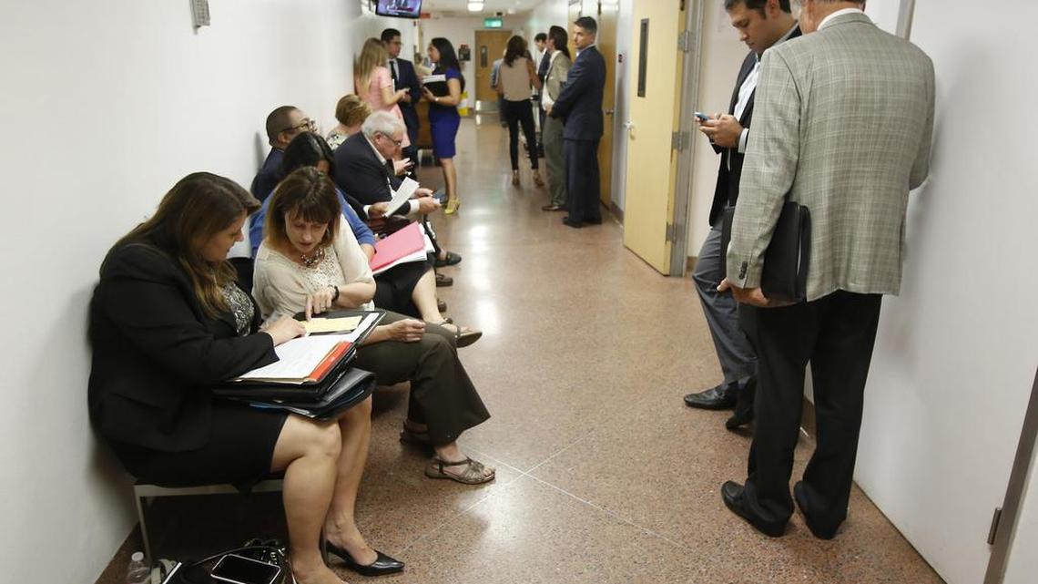 Lobbyists huddle outside the Senate Chambers as they wait to talk to lawmakers about various bills.
