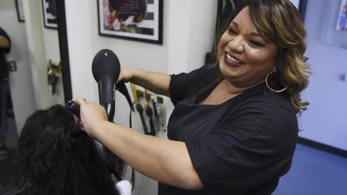 Angela Moreno, right, who is battling cancer herself, pays it forward by offering free shampoos and blow-dries at Enigma Beauty Salon for other cancer or surgery patients like Krystal Gonzalez, seated to the left, who cannot do it themselves.