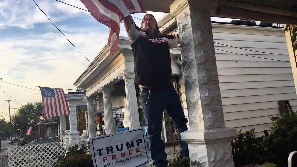 Terry Wright, a 59-year-old retired union painter, adjusts the U.S. flag on his porch in a white, working-class neighborhood in Louisville, Ky., on Nov. 1. He backed candidate Donald Trump, but President Trump isn’t doing much to help the white working class.