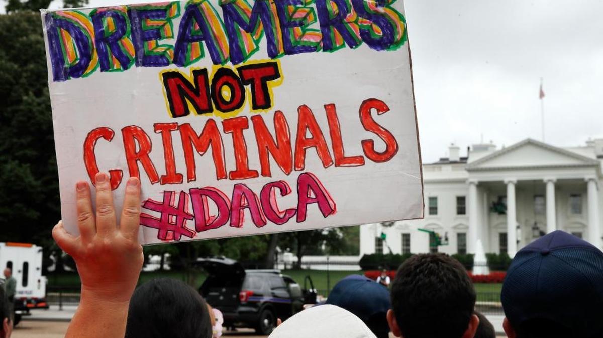 A woman holds up a signs in support of the Deferred Action for Childhood Arrivals program during an immigration reform rally at the White House on Aug. 15.