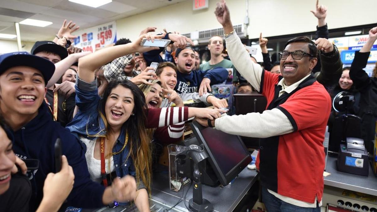7-Eleven store clerk M. Faroqui celebrates with customers after learning the store sold a winning Powerball ticket in Chino Hills.