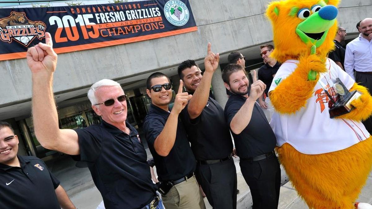 
Chris Cummings, Fresno Grizzlies managing general partner and president, left, leads team staff and Parker in saying “We’re number 1” at City Hall on Thursday after a special ceremony honoring the Pacific Coast League and national champion AAA baseball team. 
