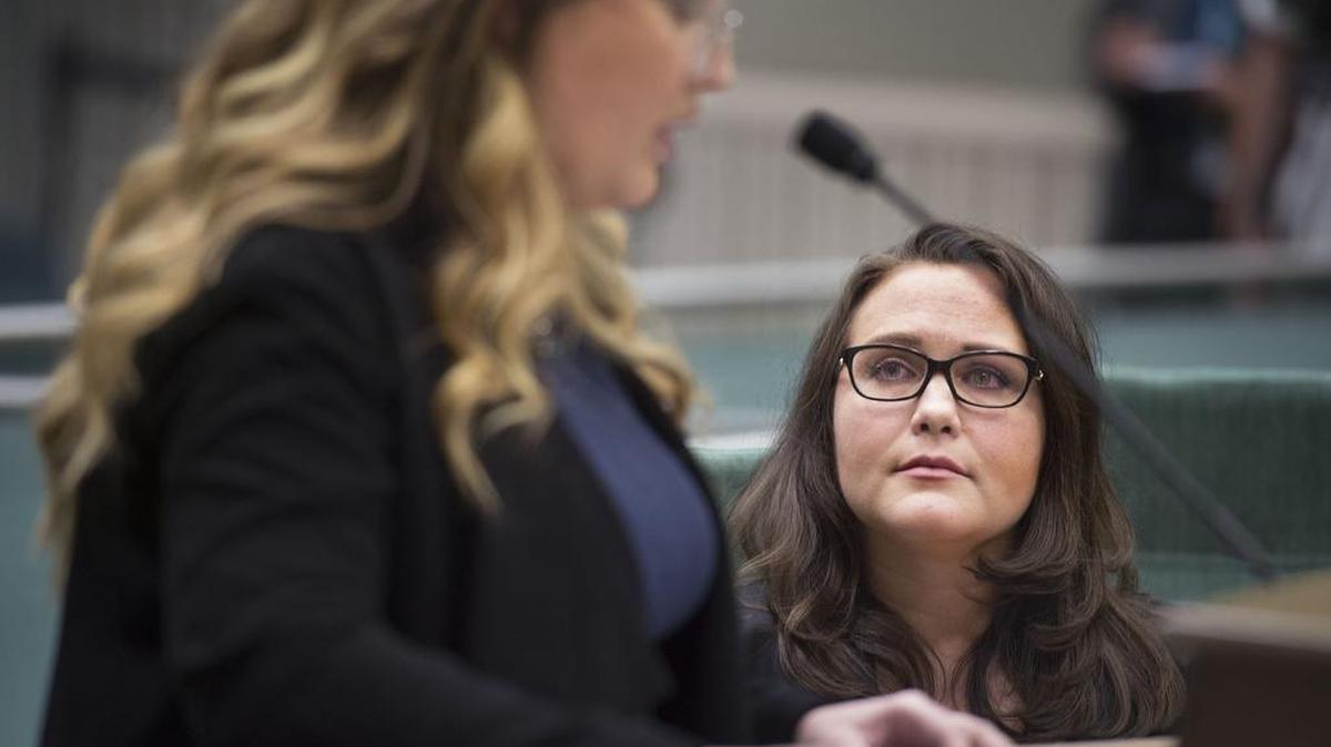 Jennifer Kwart, left, speaks at the podium as Pamela Lopez watches. Both testified at a public hearing Tuesday on sexual harassment in the Legislature