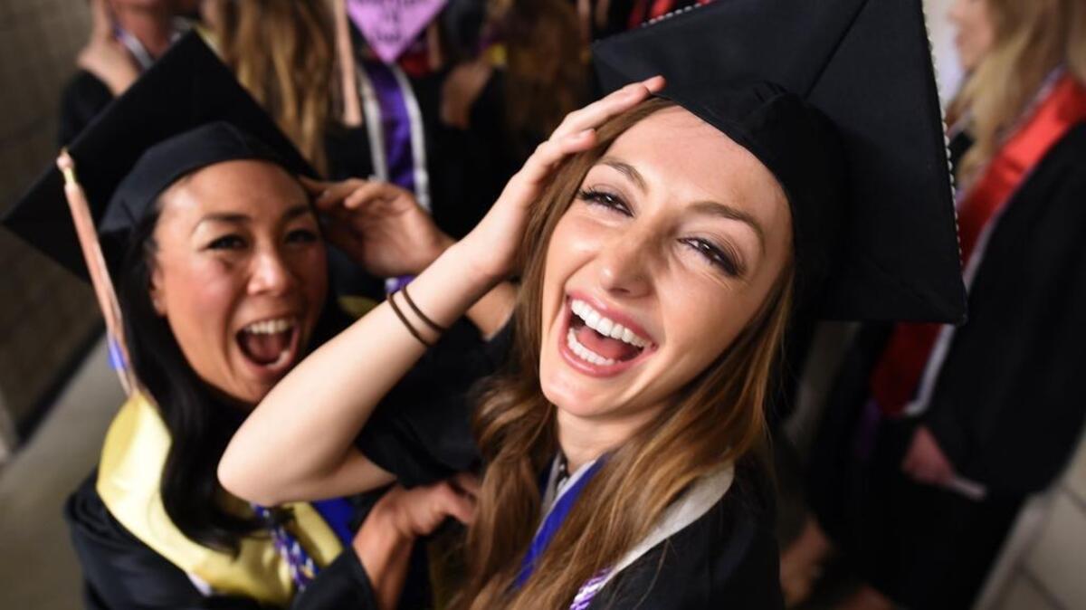 Fresno State School of Health and Human Services graduates Allison Faeth and Zara Sellares, left, pose for photos before commencement ceremonies at the Save Mart Center on May 20. According to the Bureau of Labor Statistics, college graduates in the U.S. earn an average of $1,277 a week compared to $678 for high school grads.