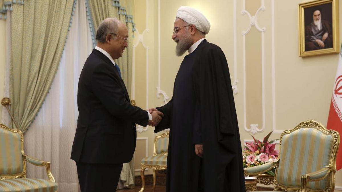 Iranian President Hassan Rouhani, right, welcomes the International Atomic Energy Agency’s director general, Yukiya Amano, at their meeting in Tehran on Monday. The IAEA certified Saturday that Iran has complied with a nuclear deal.