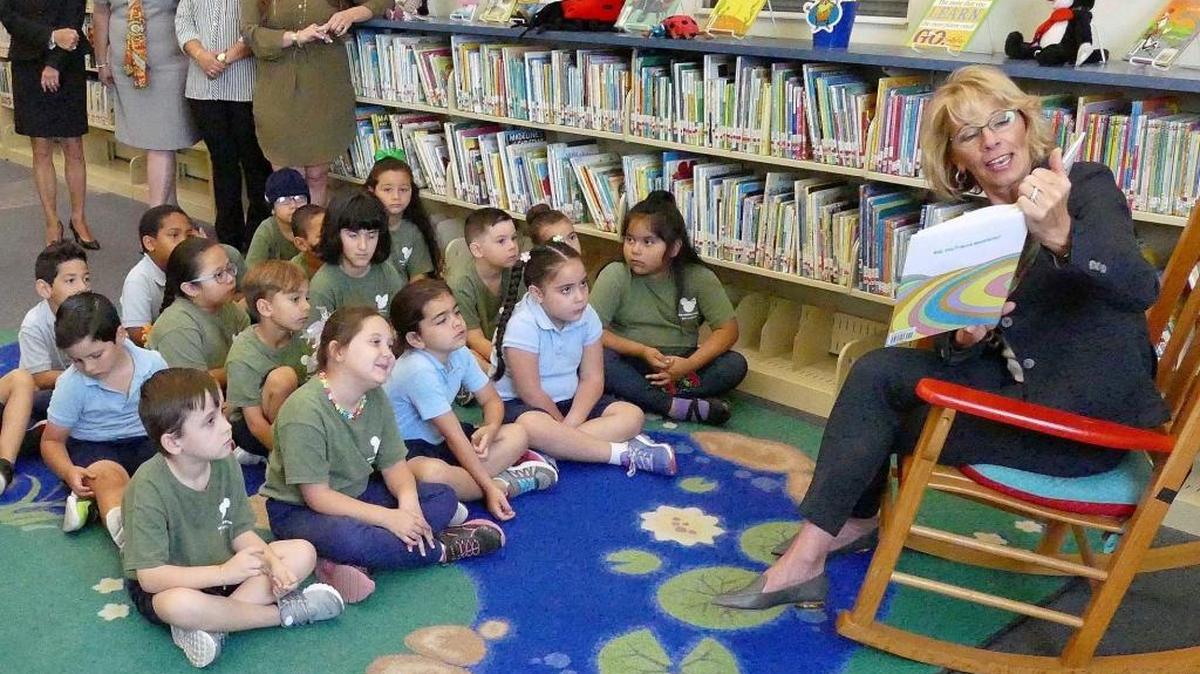 Secretary of Education Betsy DeVos reads Dr. Seuss to kindergarten students in Miami earlier this year. DeVos says that allowing parents to decide where their children will be educated is essential. The California Legislature, however, disagrees. It killed a bill that would have allowed foster kids, children receiving free school lunches and English-language learners to attend the public school of their choice.