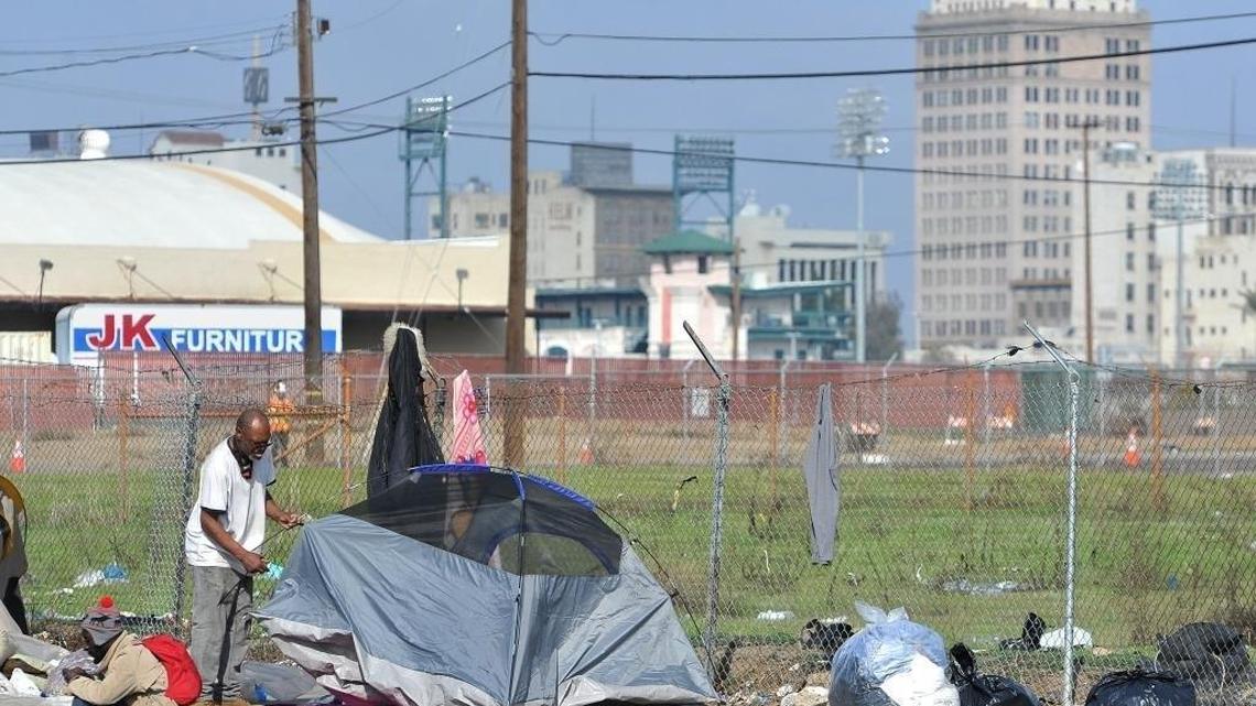 A homeless man sets back up his tent after the daily clean-up sweep enforced by the police department as part of Fresno’s no-camping ordinance.