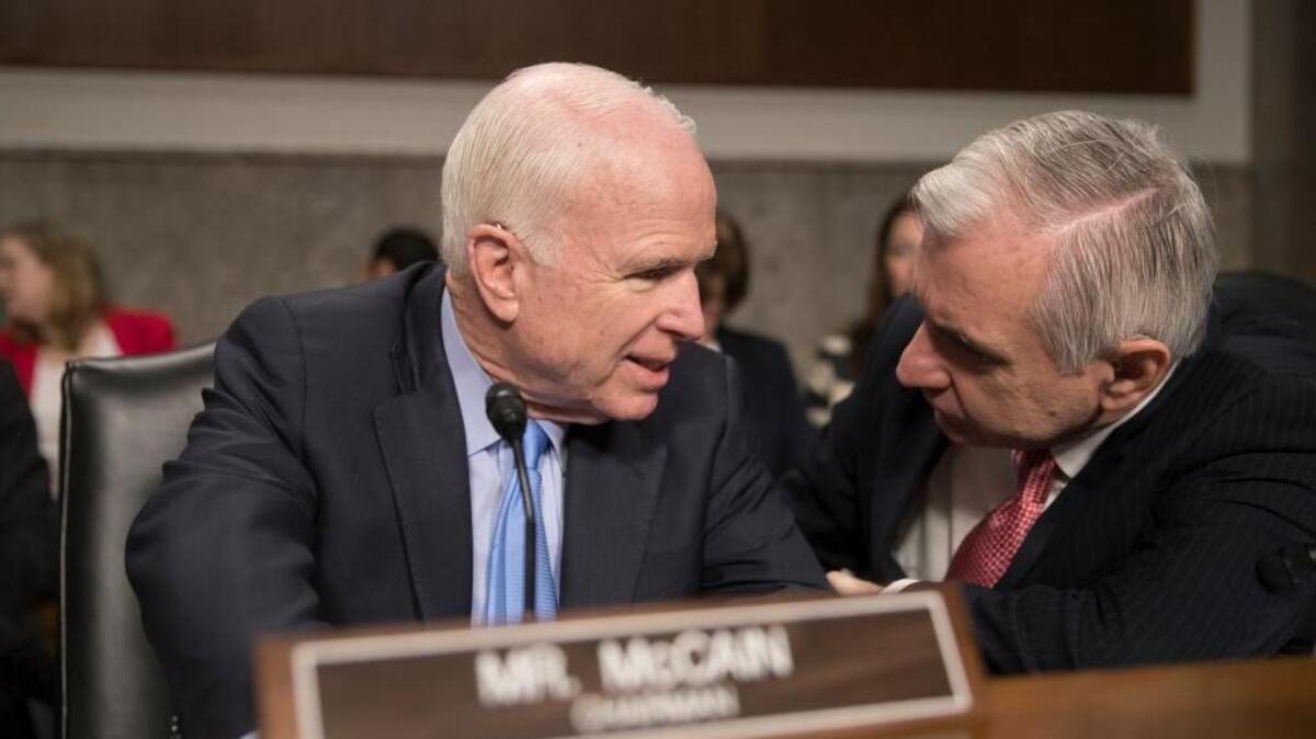 Sen. John McCain, left, confers with Sen. Jack Reed, D-R.I., during an Armed Services Committee hearing Thursday, Feb.9, on Afghanistan.