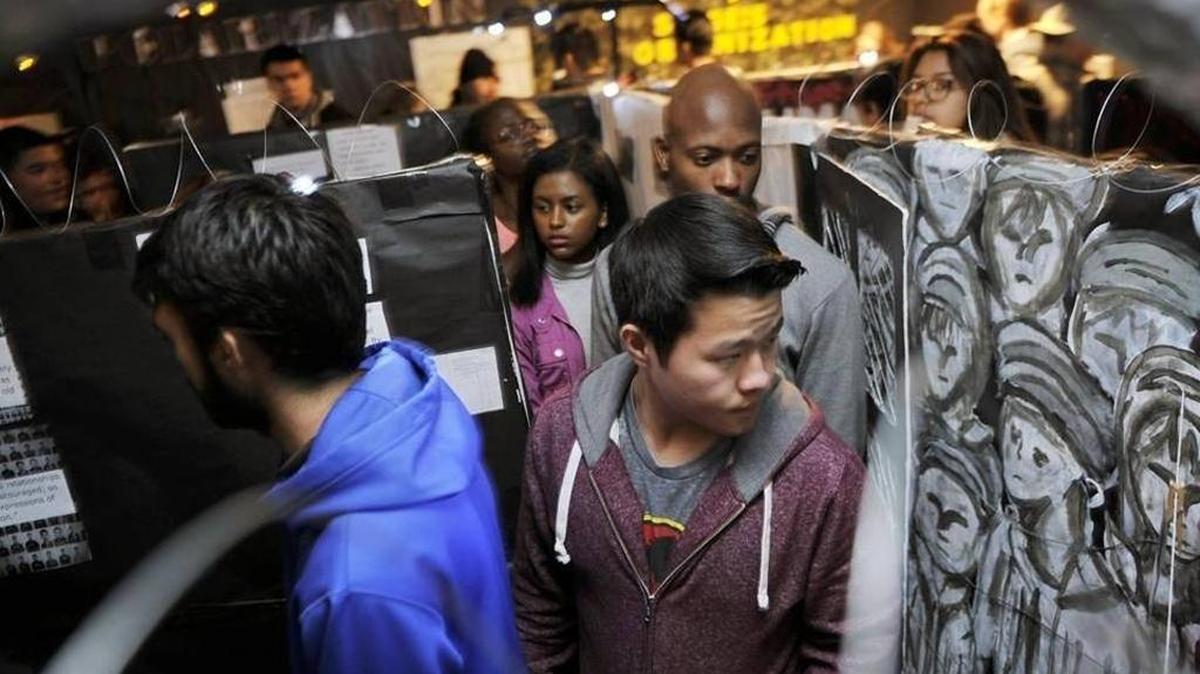 Tristen Lee, center, glances towards the awl as he and other students at Central High East Campus tour a genocide exhibit on Thursday, Feb. 4. Modern World History students have created a Genocide Remembrance Museum to honor victims of genocide. Parents were also invited to view the project.
